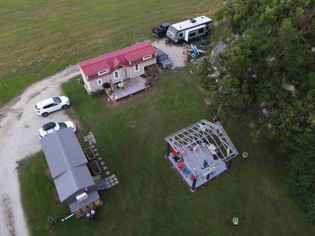 Cluster of tiny homes on wheels around a community pavilion and garden beds at Burleigh Plantation, Grand Coteau, Louisiana.